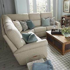 a living room with two couches, a coffee table and several pillows on the floor