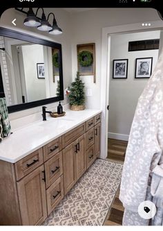 a bathroom with a large mirror and wooden cabinets