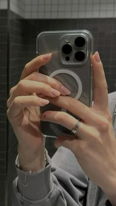 a woman taking a selfie with her cell phone in the mirror while wearing rings