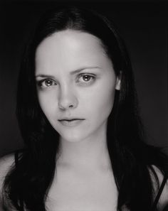 a black and white photo of a woman with long dark hair wearing a tank top