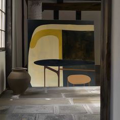 a vase sitting on the floor in front of a painting with yellow and black shapes