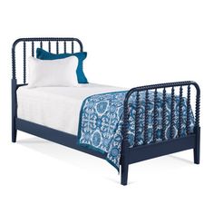 a black metal bed with blue and white sheets