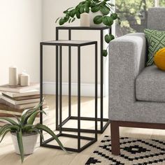 a living room with a couch, chair and potted plant on the side table