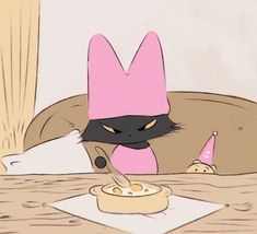 a black cat wearing a pink hat sitting at a table with a bowl of food in front of it