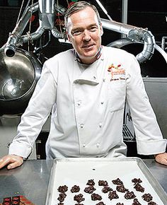 a man standing in front of a tray of cookies