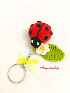 a crocheted ladybug keychain with a flower attached to it