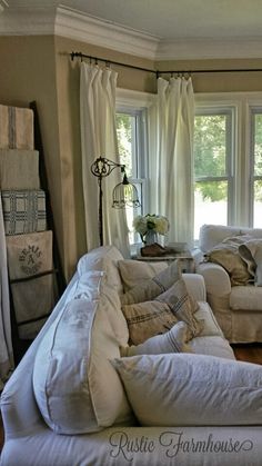 a living room filled with lots of white furniture