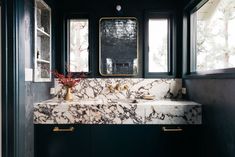 a black and white bathroom with marble countertops, gold trimmings and brass fixtures