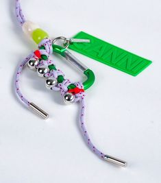 a pair of scissors and some string on a white surface with a green tag in the background