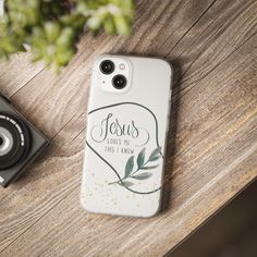 a white phone case sitting on top of a wooden table next to a black camera