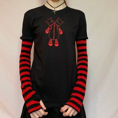 Embroidered with red stitching & button eyes Hand printed on a 100% cotton t-shirt with an Acidcore label. Red & black stripe sleeves sewn into the top with thumb holes & fingerless gives this top grunge goth vibes. About Me:  Acidcore is my store based in London. All my items are hand printed with hand made transfers and some are hand embellished. My designs are inspired by different genres, gothic, fairycore, cottagecore, punk, indie. Casual Black Tops With Striped Cuffs, Fitted Striped Tops For Streetwear, Cotton Crew Neck Tops With Striped Cuffs, Emo Long Sleeve Cotton T-shirt, Emo Style Long Sleeve Cotton T-shirt, Cotton Long Sleeve T-shirt With Striped Sleeves, Fitted Cotton Tops With Striped Cuffs, Red Emo Graphic Print Top, Red Emo Tops With Graphic Print