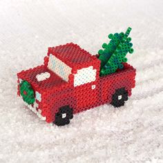 a red toy truck carrying a christmas tree