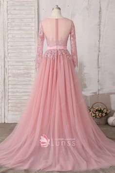 a pink long sleeved prom dress with sheer tulle and appliques on the waist