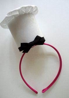 a roll of toilet paper with a black bow on it's headband sitting on a white surface