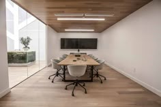 an empty conference room with white chairs and a wooden table