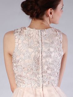 the back of a woman's dress with an intricate lace top and pleated skirt