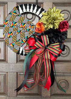 a door hanger decorated with ribbons and flowers on a wooden door frame, next to a decorative wreath