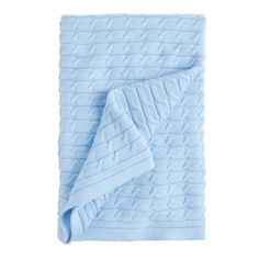 a blue blanket folded on top of a white background with an image of a cabled design