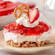 a dessert with strawberries and whipped cream is on a plate next to a fork