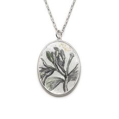 This one of a kind botany inspired, oval hand painted enamel necklace is inspired by a botanical illustration of a jasmin flower. I have adapted an image that I came across in an antique book. The jasmin flower is painted with underglazes on a pre-enamelled fine silver foil and copper base. It is fired in the enamelling kiln to fuse the enamels on the silver surface. The pendant is set in the sterling silver bezel. 24K gold foils are used in the drawing. The under-fired transparent glaze creates Nature-inspired Oval Engraved Necklace, Nature-inspired Oval Engraved Necklaces, Nature-inspired Engraved Oval Pendant Necklace, Nature-inspired Engraved Oval Pendant Necklaces, Oval Silver Necklace With Pressed Flowers, Jasmine Necklace, Jasmine Plant, Jasmine Flower, Necklace For Her