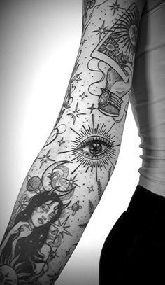 a woman's arm with tattoos on it and an eye in the middle, surrounded by stars