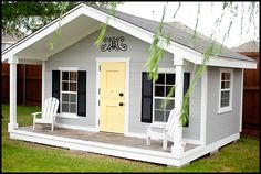 a small white house with yellow door and black shutters