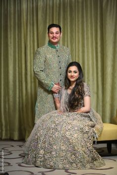 a man standing next to a woman in a dress