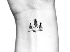 a small pine tree tattoo on the wrist