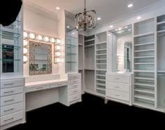 a large walk in closet with lots of drawers and lights on the ceiling, along with a chandelier