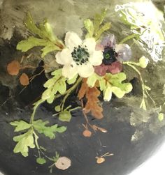 a black vase with flowers painted on it