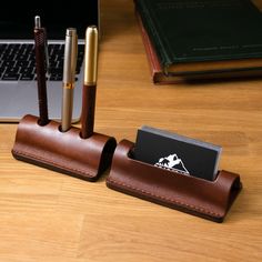 a desk with a pen holder and two pens