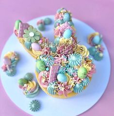 a blue plate topped with cookies covered in icing next to cupcakes and candies