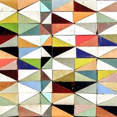 an abstract painting with many different colors and shapes on it's surface, including triangles