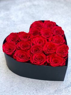 a heart shaped box filled with red roses