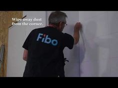 a man that is standing in front of a wall with the words fibo on it