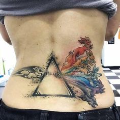 a woman's lower back tattoo with an image of animals and a unicorn on it