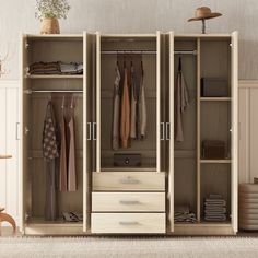 an open closet with clothes hanging on the doors and drawers, in front of a chair