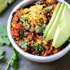 a white bowl filled with chili and avocado