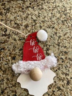 a santa hat ornament hanging from a string on top of a granite counter