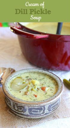 a bowl of cream of dill pickle soup next to a red casserole dish