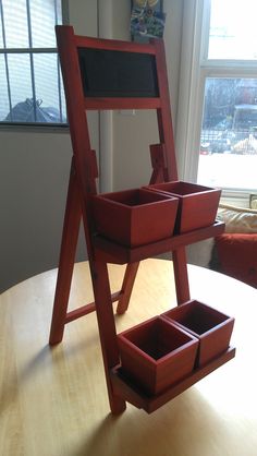 a wooden easel sitting on top of a table next to a window