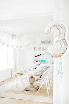 the table is set up for a birthday party with balloons in the shape of numbers