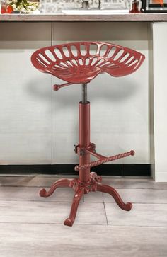 a red stool sitting on top of a kitchen floor