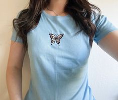 Butterfly Embroidered Tee 🦋 Ask for custom colours of design - please specify below whether you would like a Women's Fitted Tee OR Unisex, Baggy T-Shirt Model (UK Size 10) wears a Sky Blue Fitted Tee in Size Medium 👇 Please read before ordering 👇 Processing time is 3-7 Days, up to 2 weeks during busier periods. Please make sure before you order that you understand the processing time, your order may be shipped at any point during this period, processing time does not include shipping time! We Blue T-shirt With Embroidered Text For Spring, Light Blue Short Sleeve Top With Floral Embroidery, Fitted Short Sleeve Top With Embroidered Graphics, Fitted T-shirt With Embroidered Text And Short Sleeve, Trendy Blue T-shirt With Embroidered Graphics, Trendy Fitted Embroidered T-shirt, Blue Crew Neck Top With Custom Embroidery, Fitted Short Sleeve Tops With Custom Embroidery, Embroidered Fitted T-shirt For Spring