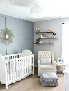 a baby's room with a white crib, chair and shelf on the wall