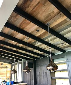 a kitchen with wooden ceiling and hanging lights