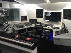 a recording studio with multiple monitors and keyboards