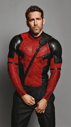 a man in a red and black costume with his hands on his hips, posing for the camera