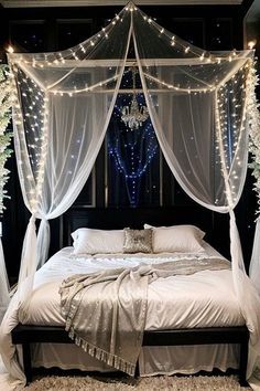 a bed with white drapes and lights on it