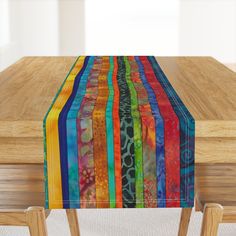 a wooden table topped with a multicolored striped table runner on top of it